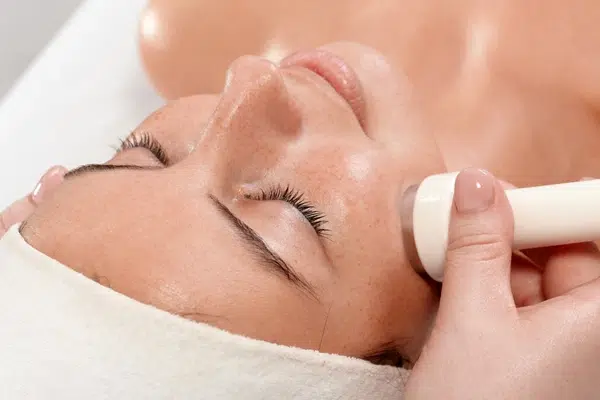 A person relaxing during a non-invasive microdermabrasion session, symbolizing the gentle rejuvenation of skin for a brighter complexion.